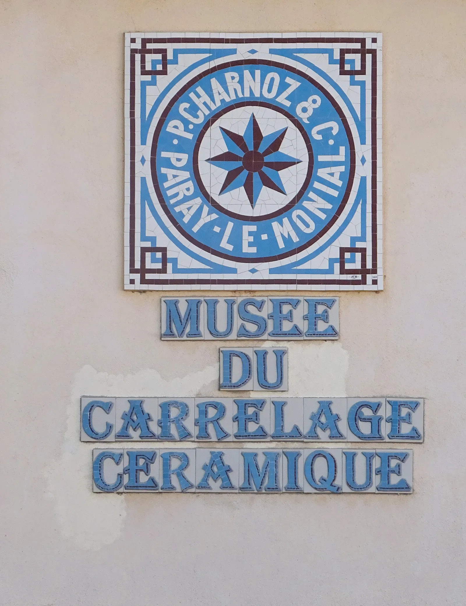 Tiled sign of P. Charnoz & Cie and the Musée du Carrelage Céramique on the museum wall