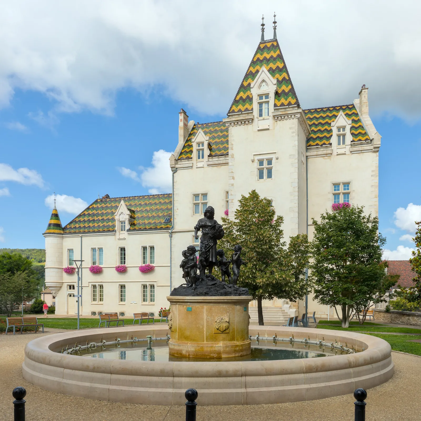 The château of Meursault, now its town hall, with its glazed tile roofs and the fountain in front