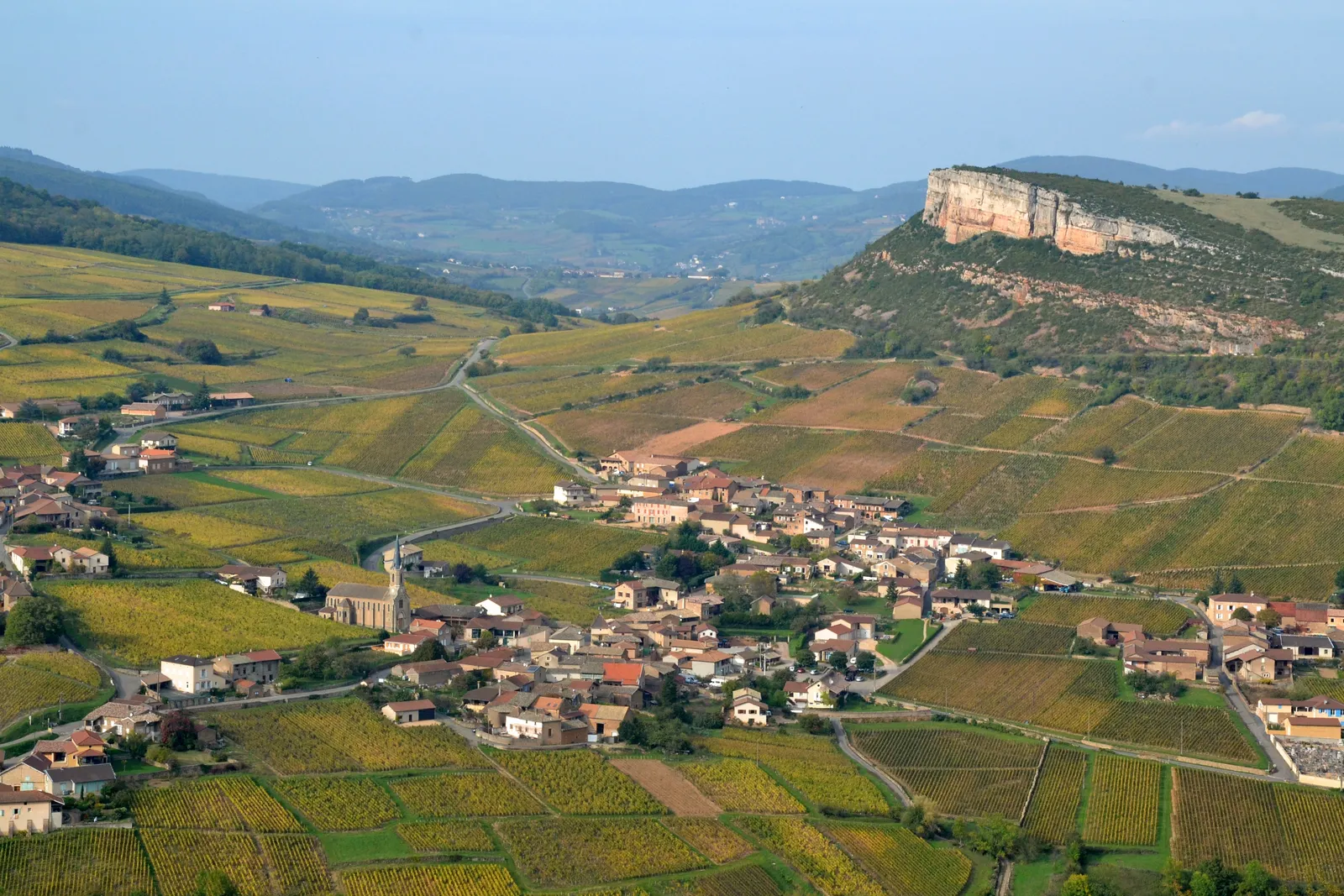Vergisson and its rock above the autumn vines of Pouilly-Fuissé, seen from the Rock of Solutré