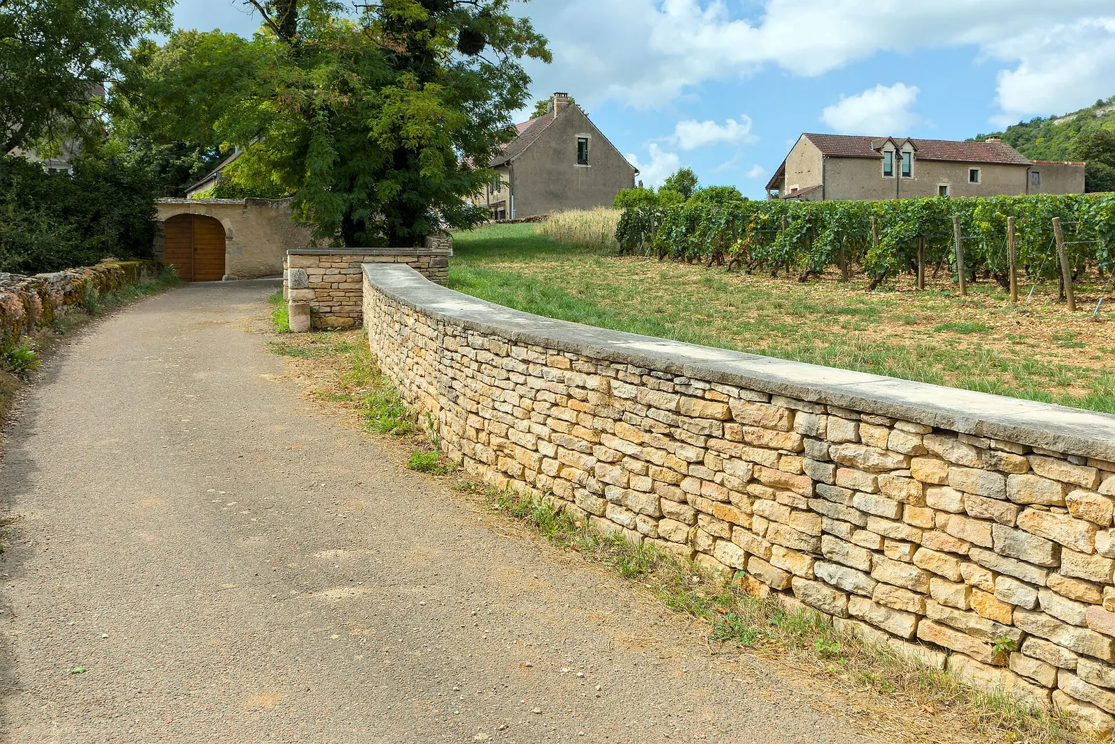 The entrance to the hamlet of Blagny, between dry-stone walls and vines